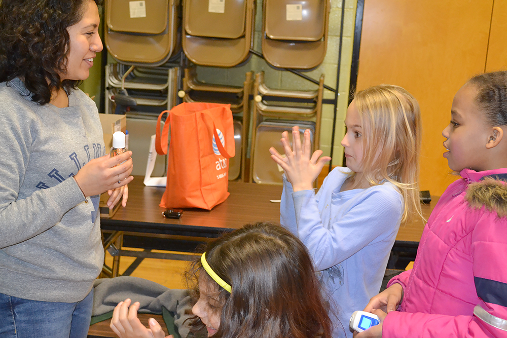 An Illinois student interacts with young visitors during Cena y Ciencias.