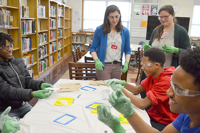Maggie Mahmood and Pamela Pena Martin (standing) interact with Franklin students who have finished "destroying" their Magnadoodles.