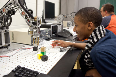 Boy working with robot on campus tour.