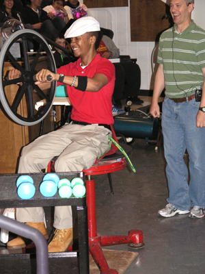Student helps Professor Pitts demonstrate the conservation of angular momentum.