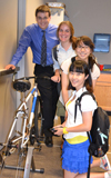 Power House team poses by the prototype of their power-generating stationary bicycle.