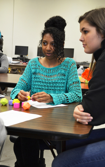 A high school student uses geometric shapes to conceptualize a math principle during the Tap-In after-school program hosted by Illinois Geometry Lab.