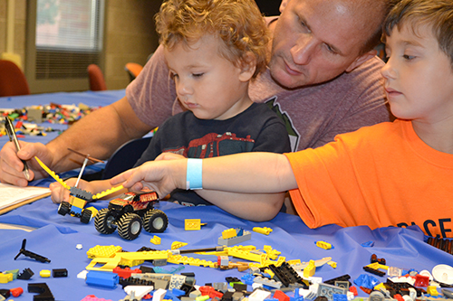 Two brothers build spacecraft during ISD's Lego hands-on activity.