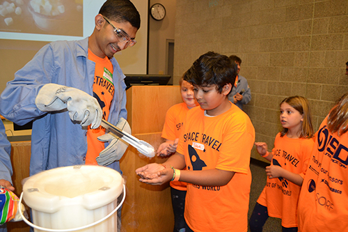 An Illinois Space Day volunteer gives young visitors marshmallows frozen in liquid nitrogen.