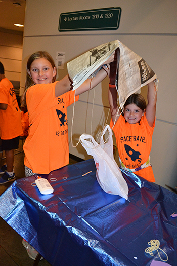 Two young visitors show off the parachute they built for the egg drop activity.