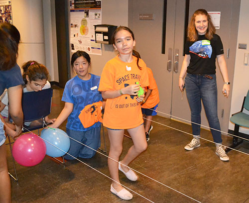 Katie Carroll (right) does an activity with young visitors at Illinois Space Day in fall 2018.