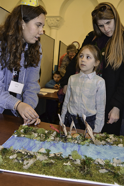 Illinois sophomore Emily Alameda does the Crossing the River acitvity with a local youngster at the Riddle Mania station during the Math Carnival: Gathering for Gardner.