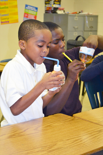 Two local youngsters blow through straws in order to observe the Bernoulli principle for themselves.
