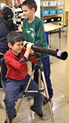 Student looks through a telescope