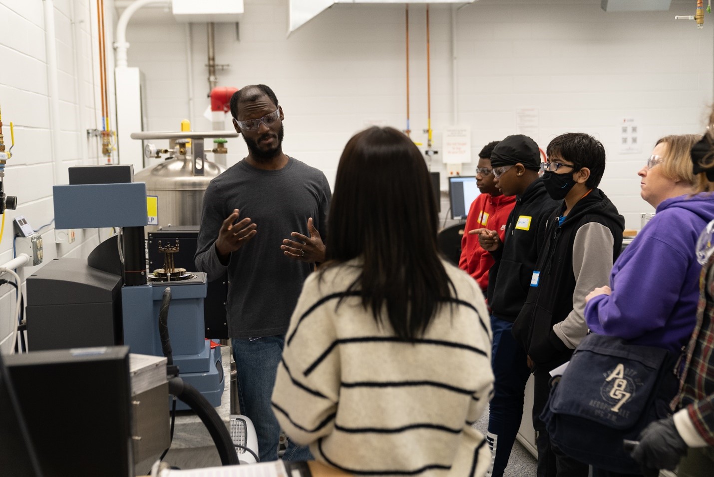 Dr. Roddel Remy shows a group of students the dynamical mechanical analyzer
