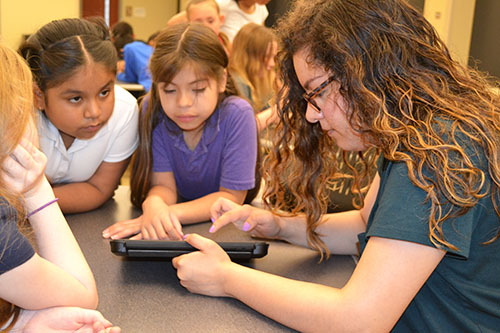 Lina Flores helps IPA 3rd graders program their Dash robot.