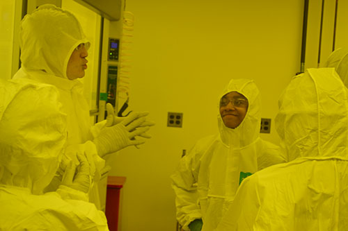 Tao Shang explains how MRL's cleanroom works to several Franklin students who are suited up and enjoying the experience.