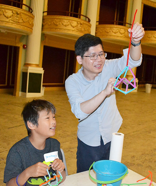 Jie Feng (right) and a boy at the Orpheum outreach appreciate the 3D wand Feng created.