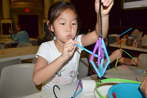 A young girl at the  at the Orpheum outreach uses the 3D wand she designed to make bubbles.