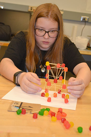 A  Mid-GLAM camper works on her team's toothpick/gumdrop structure.