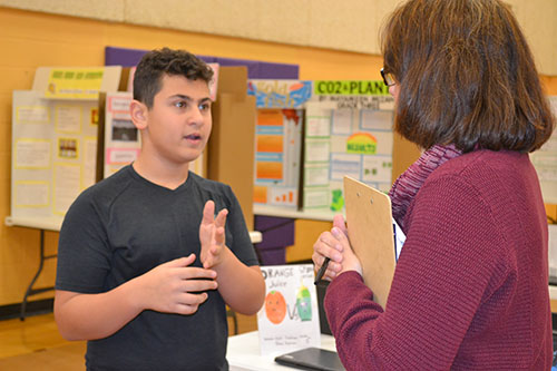 An NGS student shares his research with a community expert.