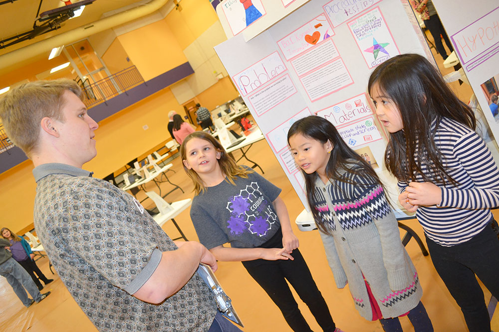 A team of NGS primary students present their research to Illinois biochemist Maxwell Baymiller.
