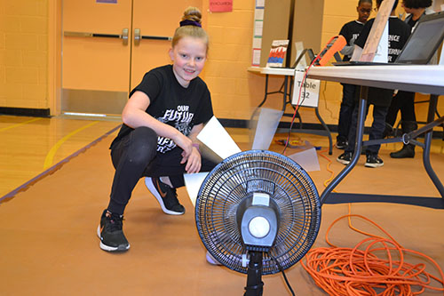 A Next Generation School student demonstrates the prototype she designed and built for her project about wind turbines.