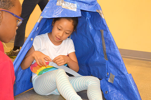 A student works on the inside of her team’s tent.