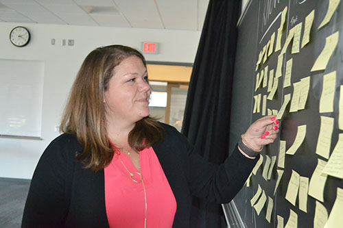  Megan Pollock studies the educator's "Aha moment" notes written as a result of her sessions on equity and inclusion the first week of the institute. 