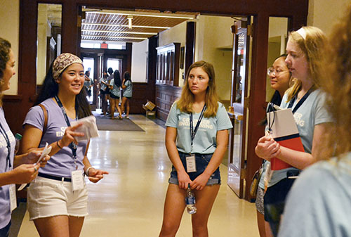 Engineering freshmen listen as their mentor (left), an older engineering student, shares during one stop in the Engineering Building during the 2019 WIE Orientation's resource tour.