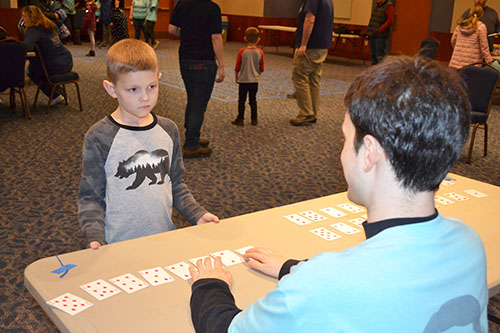 A  math  student interacts with a young visitor at the <em>Fun with Sorting  Algorithms</em> game.