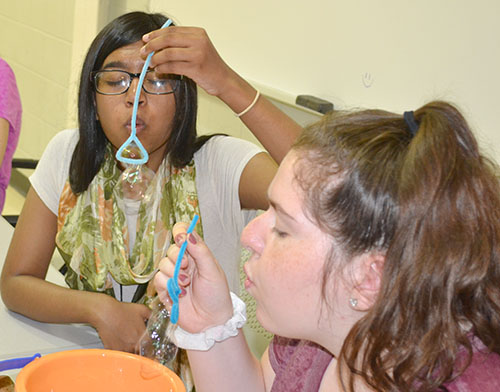 WYSE high school students blow bubbles out of the wands they created.