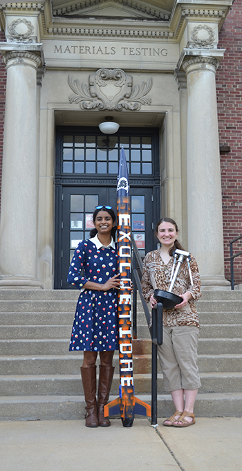 Shivani Ganesh and Courtney Leverenz in front of Talbott Lab with some things they built as part of ISS.
