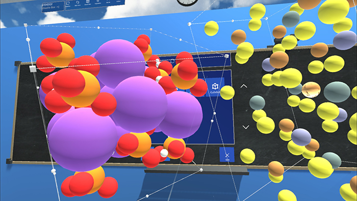 Schleife's slide showing students how VR can be used to study materials. For instance, in the above slide,  the material with purple atoms on the left is monopotassium phosphate and is part of fertilizers, sports drinks, and used for optical applications; the material on the right, with yellow atoms, is Copper Zinc Tin Sulfide, which is used for solar cells.