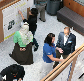 Irfan Ahmad (right) discusses one of the institute participant's research during a poster session.
