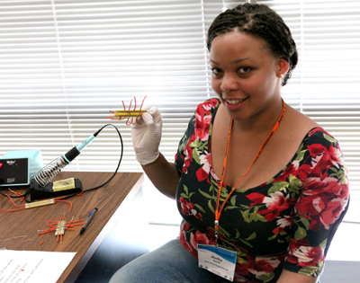 Participant displays an instrument she made during one of the engineering modules.