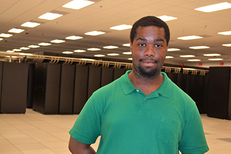 Blue Waters intern William Leverette poses in front of the Blue Waters supercomputer during a tour of the Petascale facility.