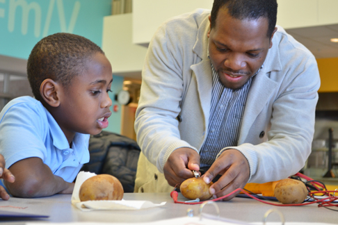 Jerrod Henderson helps a youngster with his potato battery.