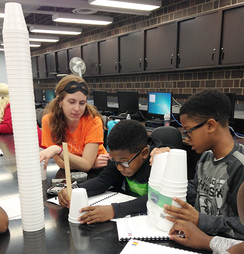  <em>Illinois</em> Engineering student Emily Matijevich (left) supervises while two Chicago students do a hands-on activity during one of the Fall 2015 ChiS&E workshops at UIC. (photo by Sahid Rosado) 