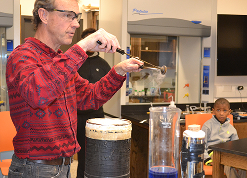Uni chemistry teacher David Bergandine demonstrates to the youngsters that liquid nitrogen can make metal molecules denser, thereby making the metal itself contract.