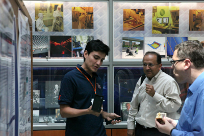 Dustin Gallegos (left) and Rashid Bashir (center) have a discussion during a poster presentation.