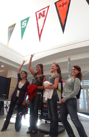 Asha Kirchoff, Christine Littrell, Jenny Ernthaller, and Jenny Amos point to the Illinois banner on the Penn State campus