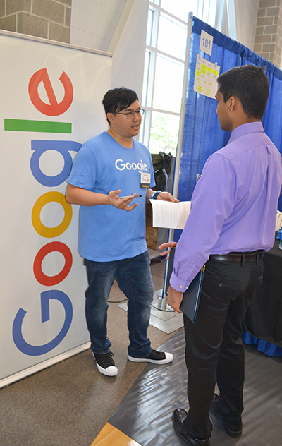 An<em> Illinois</em> engineering student (right) chats with an Illinois alum who was recruiting for Google.