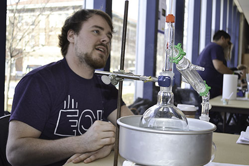 A Chemical Engineering student and member of OXE (Omega Chi Epsilon) mans an exhibit about distillation.