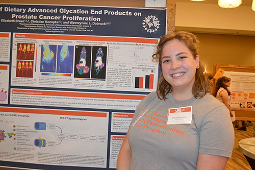 Fordham University undergrad Elizabeth Breen by her poster about how certain elements in the Western diet proliferate cancer.