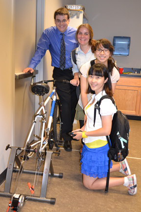 PowerHouse Team poses by their stationary electric bike prototype.