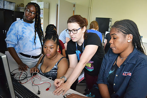 Jenny Amos (center) works with several Bioengineering GAMES campers on a lab activity.