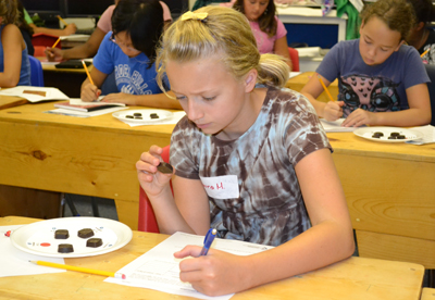 GIRRRLS camper examines bloom on chocolate during hands-on activity.
