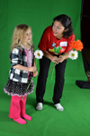 A local youngster and Illinois grad student Lorna Rios stand in front of a green screen to "dance with plants."