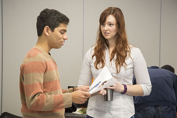 Katie Ansell helps  a Physics 211 student resolve an issue he's having with the lab instructions.  (Image courtesy of Brian Stauffer.)