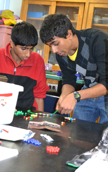BioE student Manu Kumar (right) works with student during hands-on activity about plasmids.