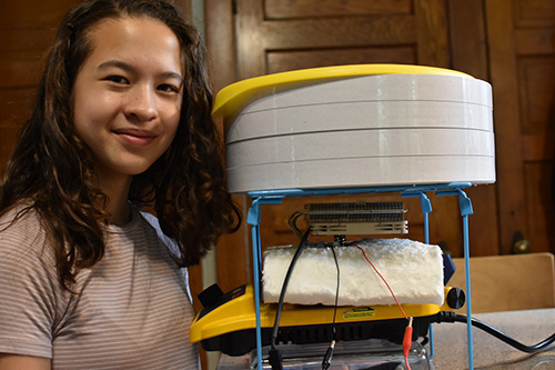 Lily Weaver tests the Sun Bucket's effectiveness for drying various fruits and grains. (Image courtesy of Lily Weaver.)