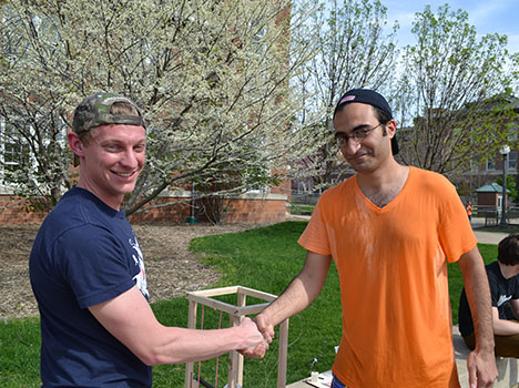 Sameh Tawfick (right), shakes hands with the ME370 student who successfully dunked him.