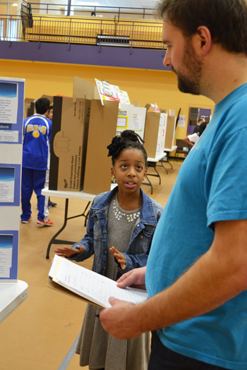An NGS student presents her research to a community expert.