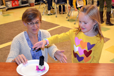 Kathy Feser and a kindergartener test her structure in front of a box fan.